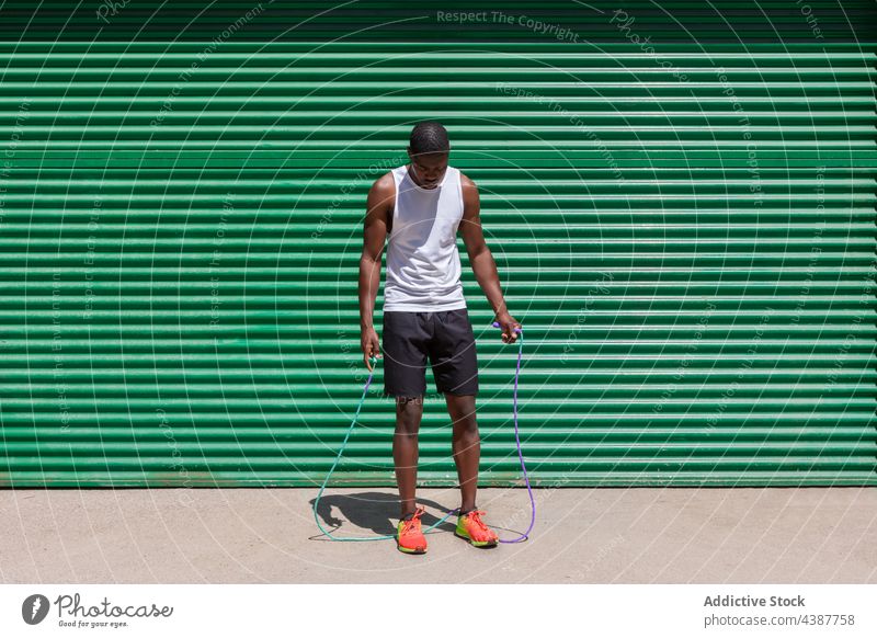 Schwarzer fitter Sportler, der beim Training Seil springt schwarz Hüpfseil springen überspringen Herz Übung Athlet Großstadt männlich ethnisch Afroamerikaner