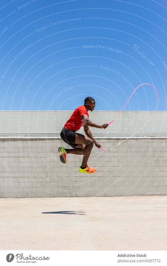 Fit schwarzer Sportler springt Seil während des Trainings Hüpfseil springen Moment Herz Übung aktiv Energie Athlet männlich ethnisch Afroamerikaner Mann Fitness