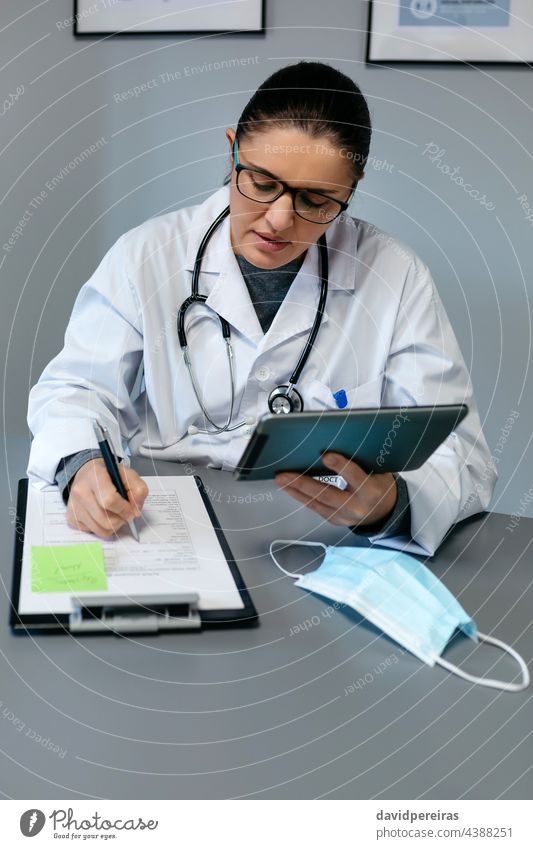 Weiblicher Arzt bei der Online-Konsultation mit der Tablette Telemedizin medtech medizinische Online-Beratung Frau arbeiten schreibend Videoanruf
