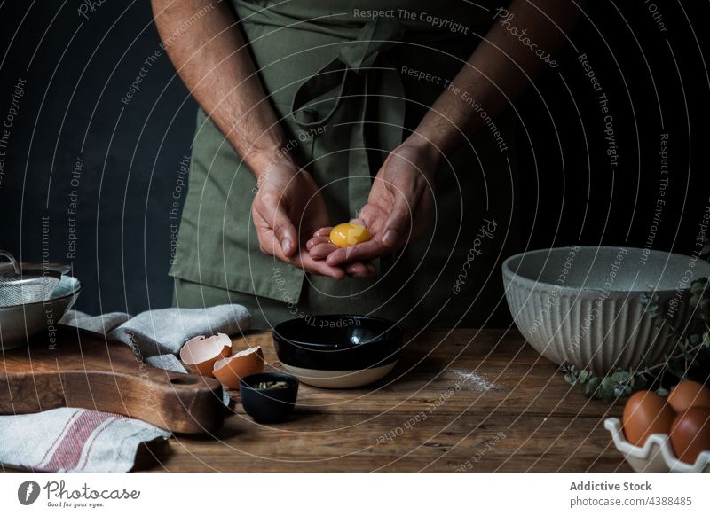 Kappenmann schlägt Ei für Gebäck auf Mann Pause Koch Schalen & Schüsseln Tisch Küchengeräte roh rustikal männlich Küchenchef Holz hinzufügen frisch vorbereiten