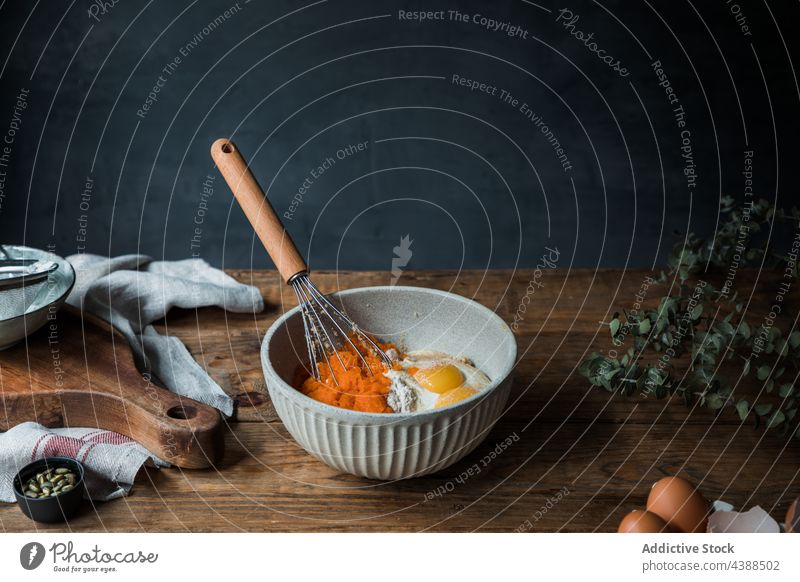 Zutaten für Kürbiskuchen mischen Bestandteil Pasteten Koch Tisch rustikal Schalen & Schüsseln Schneebesen Püree Sahne Mehl Ei Handtuch Schneidebrett Küche