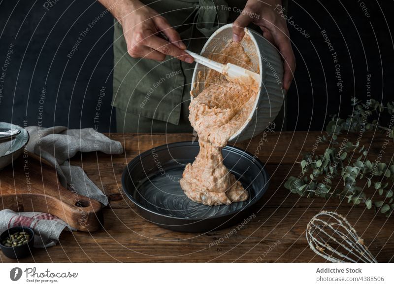 Crop Cook Teig in die Form streichen Mann Koch Pasteten Kürbis Büchse Aufstrich Tisch rustikal Spachtel männlich Dessert Küche Küchenchef Holz Gebäck Speise