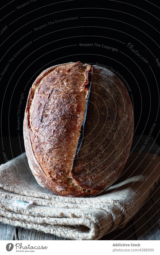 Hausgemachtes Sauerteigbrot auf schwarzem Hintergrund Brotlaib gebacken frisch Lebensmittel Roggen Gesundheit organisch Korn lecker traditionell selbstgemacht