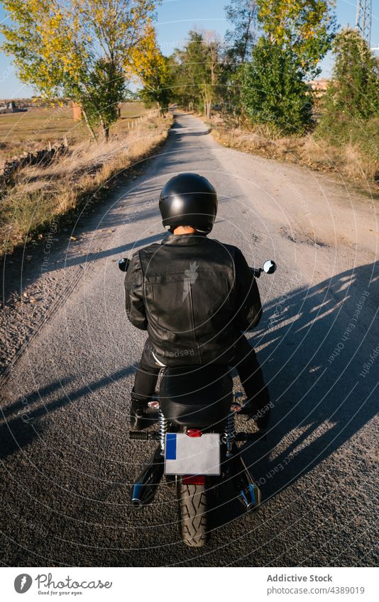 Anonymer Biker fährt Motorrad auf dem Land Straße Fahrrad reisen Asphalt schnell Schutzhelm Laufwerk aktiv Adrenalin Abenteuer anonym Herbst Rückansicht schwarz