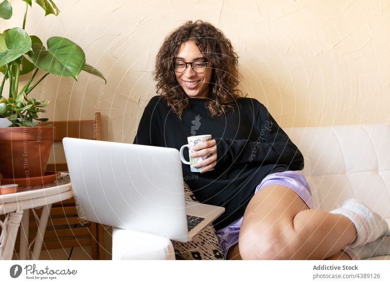 Frau mit Kaffee und Laptop beim Ausruhen zu Hause besinnlich trinken Kälte träumen nachdenklich jung hispanisch ethnisch sich[Akk] entspannen Komfort Lifestyle