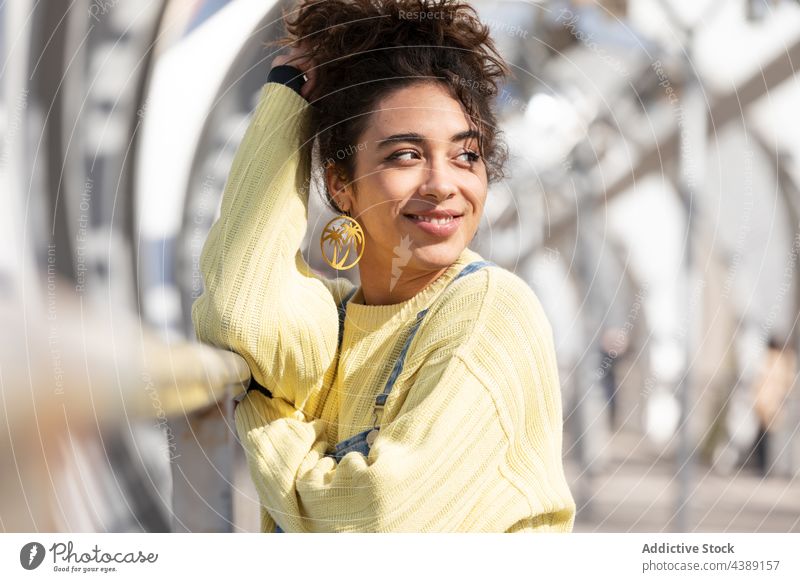 Trendige junge Frau in lässigem Outfit trendy Stil urban Teenager modern selbstbewusst Jeansstoff gelb hispanisch ethnisch tausendjährig krause Haare Aussehen