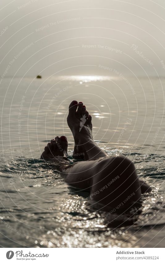 Anonyme Frau im Meerwasser liegend am Morgen MEER Wasser Lügen Sonnenlicht Urlaub Angebot früh Barfuß Playa de Muro Alcudia Mallorca Spanien genießen ruhig