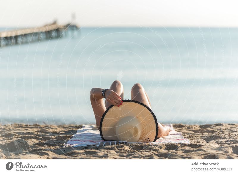 Unbekannte Frau mit Sonnenhut liegt am Strand in der Nähe des Meeres Sonnenbad Sommer Bräune Strohhut Urlaub Seeküste Feiertag Playa de Muro Alcudia Mallorca