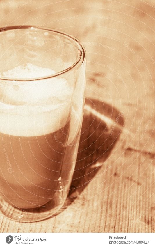 Latte Macchiato Glas auf Holztisch mit Schatten Getränk Schattenspiel Mittagspause Sommer freizeit Pause Urlaub Urlaubsstimmung Sonnenlicht genießen