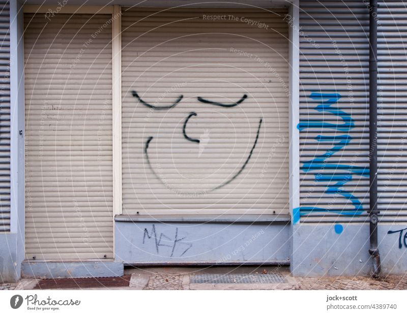 Gute Laune am geschlossenen Rollladen Spray Ladenfront Ladengeschäft Smiley Straßenkunst Eingang Comic Tür Fassade Fußabtreter Wand Stimmung positiv Lächeln