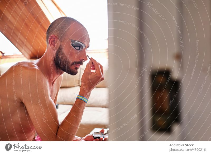 Bärtiger Mann trägt Make-up auf die Augen auf bewerben Drag Queen Transgender Kajal Augenbraue Kosmetik Geschlecht Gesicht Linse männlich Piercing Vollbart