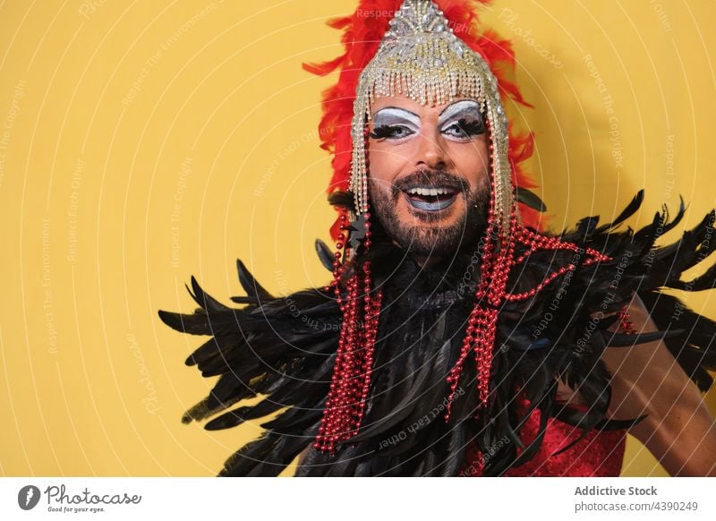 Drag-Queen-Modell in hellem Kostüm Mann Drag Queen Tracht Make-up Outfit Kopfschmuck anhaben Geschlecht Feder Transgender Accessoire Kleid Kopfbedeckung feminin