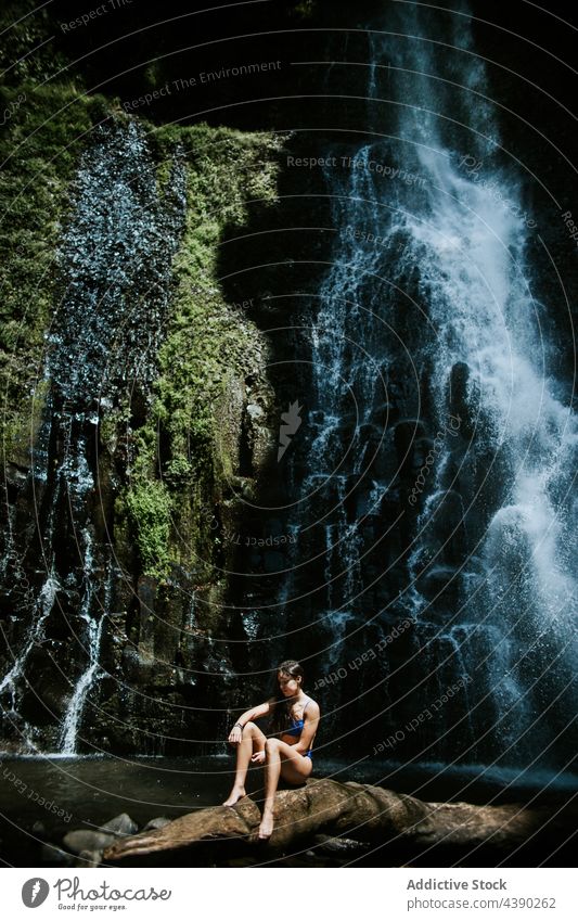 Junge Frau ruht sich in der Nähe eines Wasserfalls aus Felsen Natur Reisender Moos sich[Akk] entspannen Stein allein frisch platschen ruhen Tourist Urlaub