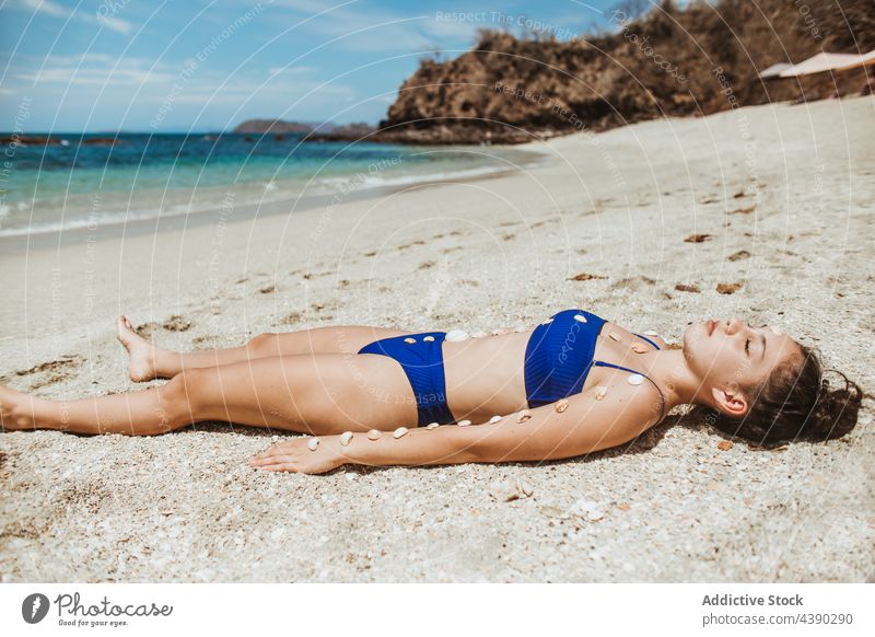 Entspannte Frau beim Sonnenbaden am Strand Meer sich[Akk] entspannen Muschel Sand allein Sommer reisen Sonnenlicht Natur MEER Urlaub Küste jung Meeresufer