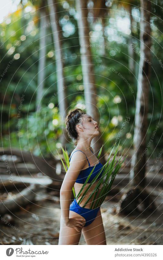 Frau mit Palmblättern am Strand tropisch Handfläche Blatt Bikini Outfit Sommer Natur Urlaub reisen Feiertag Paradies Design Pose Model jung exotisch Tourismus