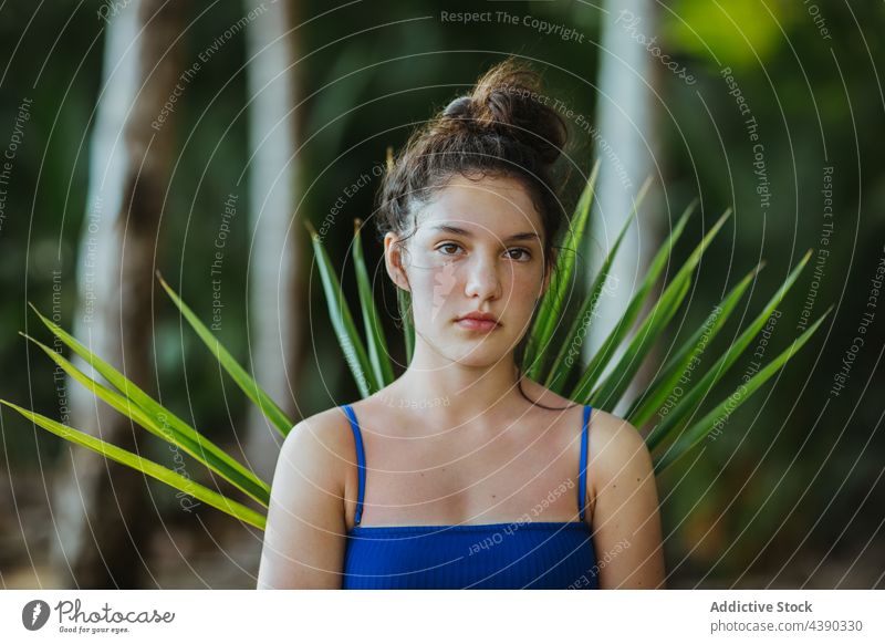 Friedliche Frau im Park stehend mit Palmenblatt Handfläche Garten tropisch Baum Blatt Ast exotisch Natur Sommer guanacaste uvita Costa Rica Gelassenheit