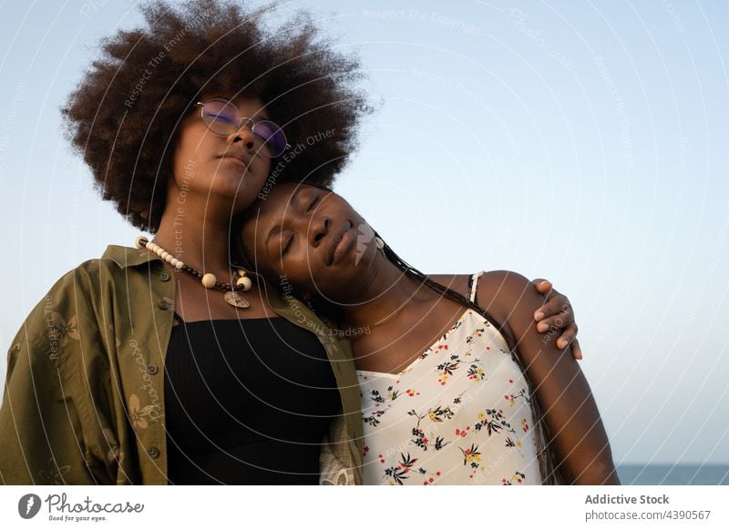 Schwarze Frauen umarmen sich am Strand bester Freund Umarmen Glück Zusammensein Liebe Sommer Freundschaft Partnerschaft Freundin Schwester Umarmung schließen