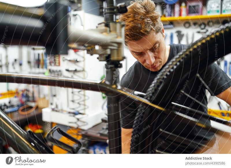 Mann repariert Fahrradrad in der Garage Techniker Reparatur befestigen Rad professionell Arbeit Dienst männlich Erwachsener Fahrradfahren Mechaniker Werkstatt