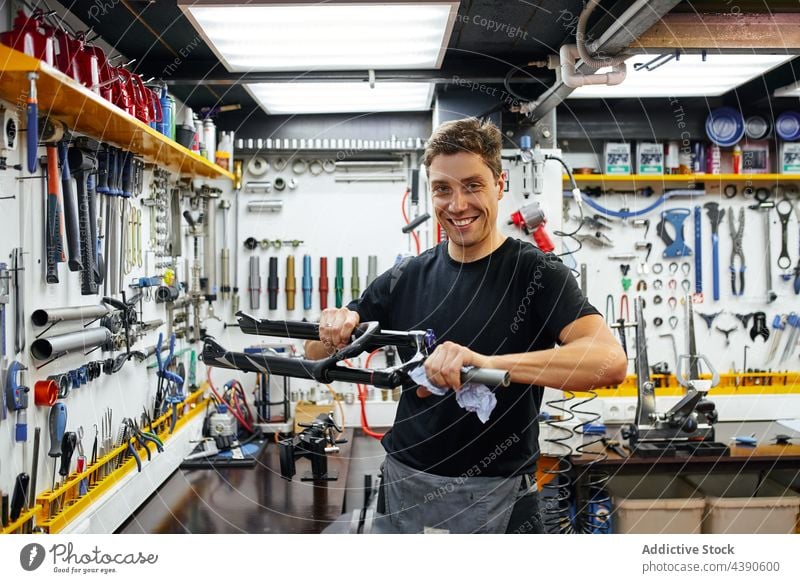 Männlicher Mechaniker beim Abwischen des Fahrradrahmens in der Werkstatt Mann Rahmen Wischen Sauberkeit Dienst übersichtlich männlich Tuch Arbeit Gerät