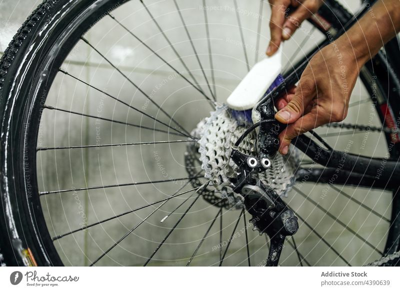 Mann beim Reinigen der Zahnkranzkassette eines Fahrrads Waschen Rad Ausrüstung Kassette Sauberkeit Bürste Werkstatt männlich schäumen übersichtlich Dienst
