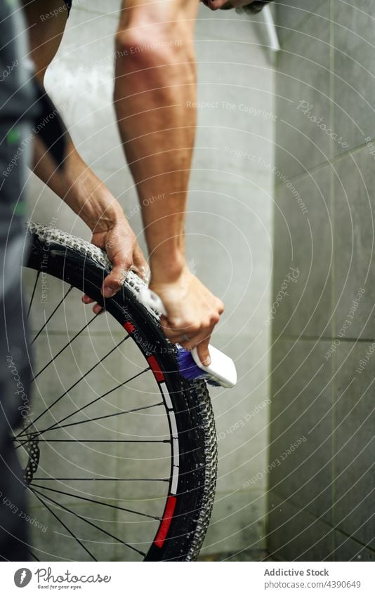 Mann beim Reinigen der Zahnkranzkassette eines Fahrrads Waschen Rad Ausrüstung Kassette Sauberkeit Bürste Werkstatt männlich schäumen übersichtlich Dienst