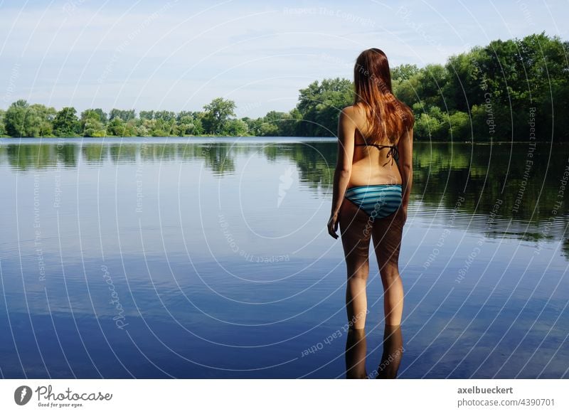 junge Frau im Bikini steht im Wasser und blickt auf See Junge Frau Badesee badeteich Teich Natur baden Schwimmen & Baden Sommer Erholung Jugendliche