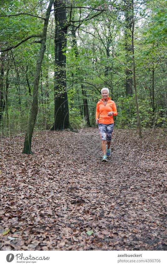 Seniorin in Sportbekleidung joggt durch den Wald seniorin Joggen Jogger Jogging laufen aktiv Fitness Gesundheit sportlich Lifestyle im Freien Frau Training