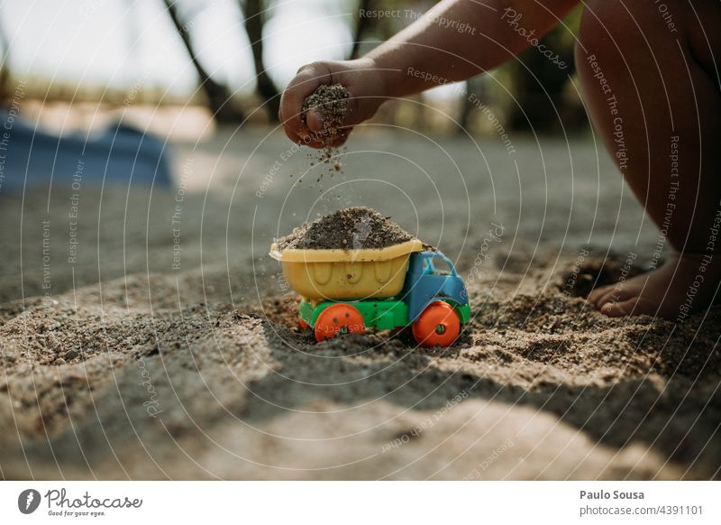 Kind spielt mit Sand und Lastwagen Spielen Spielzeug konzeptionell Baustelle Konstruktion Baumaschine Farbfoto Tag Außenaufnahme Arbeit & Erwerbstätigkeit bauen