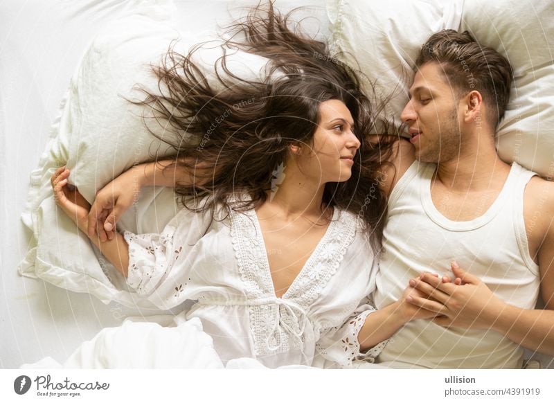 Draufsicht auf ein romantisches, attraktives, zufriedenes, junges, sexy liebendes Paar im Bett, Kopierraum Top Ansicht Leidenschaft Spaß itim Intimität Lachen