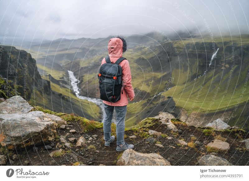 Nahaufnahme einer Frau mit Rucksack, die das isländische Hochland und den Fluss Fossa in der Nähe des Haifoss-Wasserfalls in Island genießt haifoss Tourist