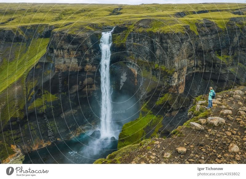 Luftaufnahme einer Frau mit Rucksack, die den Haifoss-Wasserfall im isländischen Hochland genießt Antenne haifoss Tourist reisen Natur Berge u. Gebirge Island