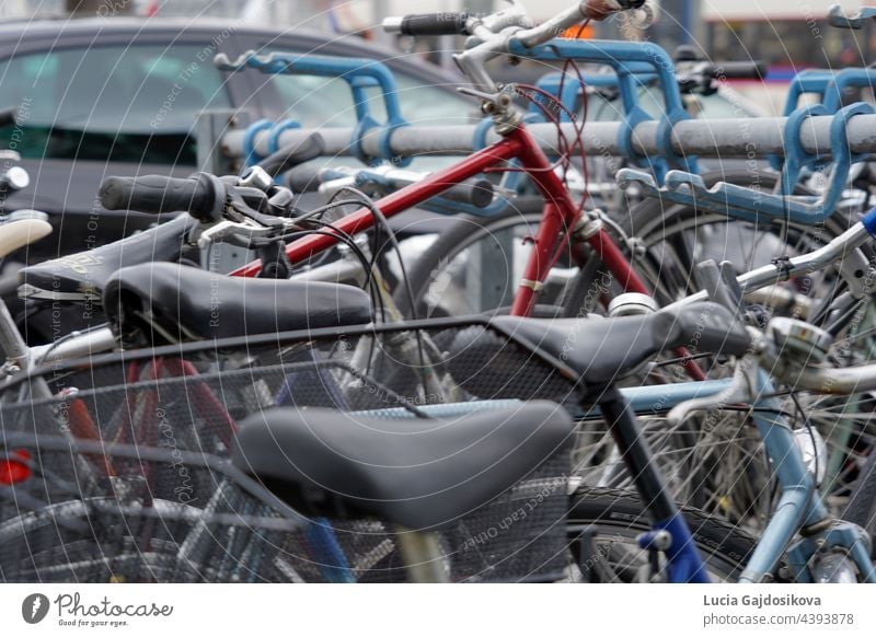 Fahrräder geparkt auf einer belebten Straße mit Autos. Hintergrundbild zu Mobilität und alternativen Verkehrsmitteln in Städten. Automobil Fahrrad