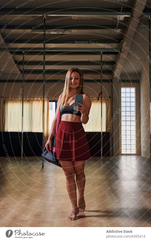 Schlanke Pole-Tänzerin beim Fotografieren im Spiegel im Studio Frau Mast Atelier Selfie fotografieren schlank Anmut Lächeln heiter passen Smartphone Gerät
