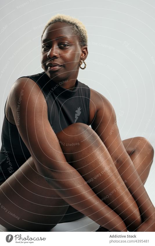 Entschlossene schwarze Frau im Bodysuit im Studio Bestimmen Sie körperpositiv Form Körper Kurve Atelier selbstbewusst akzeptieren ethnisch Afroamerikaner Figur