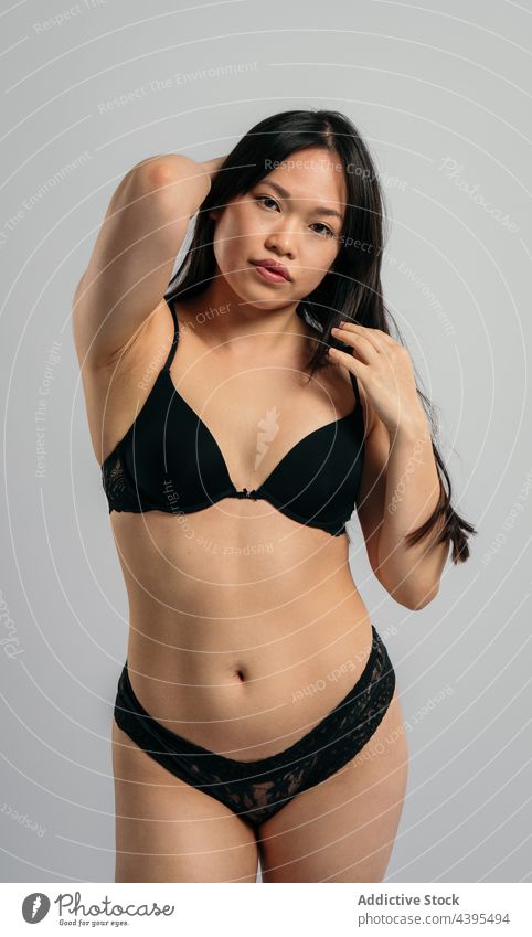 Asiatische Frau in Unterwäsche im Studio körperpositiv Dessous selbstbewusst akzeptieren Atelier Vorschein Körper Figur asiatisch ethnisch BH Frauenunterhose