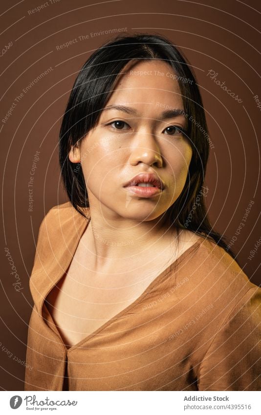 Asiatische Frau schaut in die Kamera Stil Atelier Bekleidung Model Outfit Freude trendy Vorschein asiatisch ethnisch Lächeln positiv Jeanshose jung lange Haare