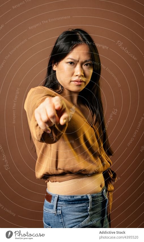 Ernste asiatische Frau, die auf die Kamera zeigt auf die Kamera zeigen du gestikulieren Zeichen Punkt sich[Akk] melden ernst Stirnrunzeln Bestimmen Sie ethnisch