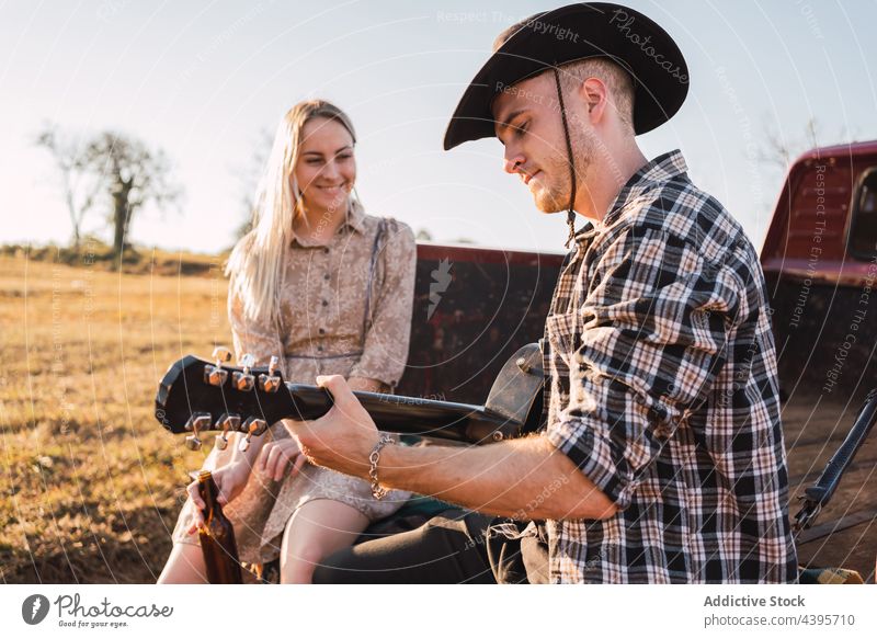 Ehepaar mit Gitarre in einem alten Pickup sitzend PKW Paar spielen Landschaft abholen retro altehrwürdig Musik Zusammensein Cowboy romantisch Freund Fahrzeug