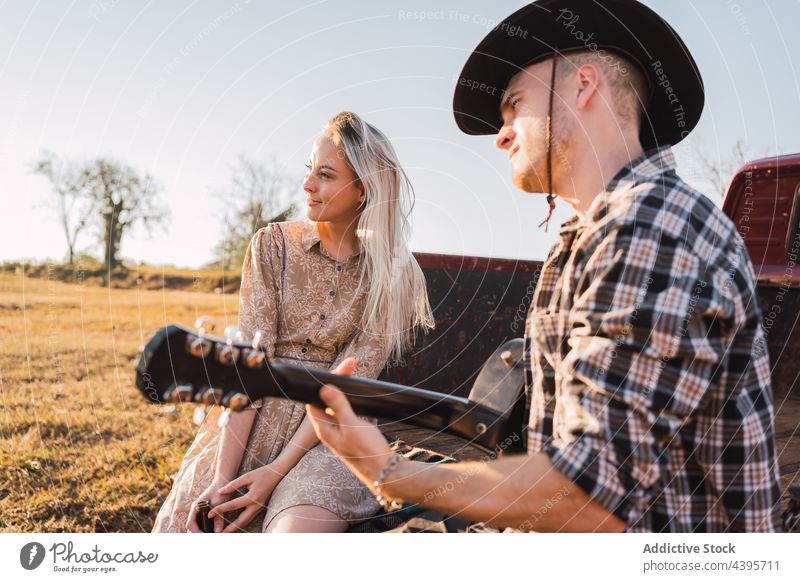 Ehepaar mit Gitarre in einem alten Pickup sitzend PKW Paar spielen Landschaft abholen retro altehrwürdig Musik Zusammensein Cowboy romantisch Freund Fahrzeug