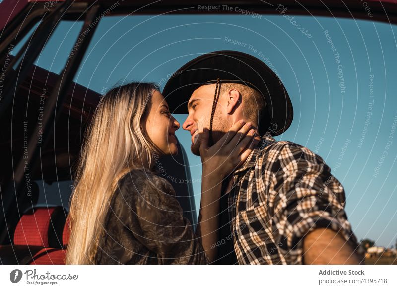 Verliebtes Paar küsst sich in der Nähe des Autos Kuss PKW Liebe Blauer Himmel romantisch Abend Sommer Partnerschaft Zusammensein Zuneigung Cowboy Angebot jung