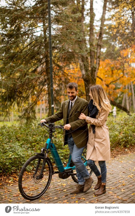 Junges Paar im herbstlichen Park mit Elektrofahrrad attraktiv Herbst schön Fahrrad Freund lässig Farbe Termin & Datum Datierung Tag e Fahrrad e-Bike ebike
