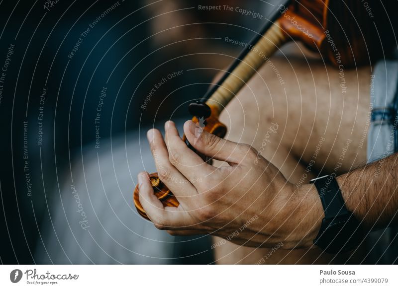 Nahaufnahme Mann stimmt Geige Geiger Streichinstrumente Musiker Holz Saite Musikinstrument Musik hören musizieren Innenaufnahme Orchester Farbfoto
