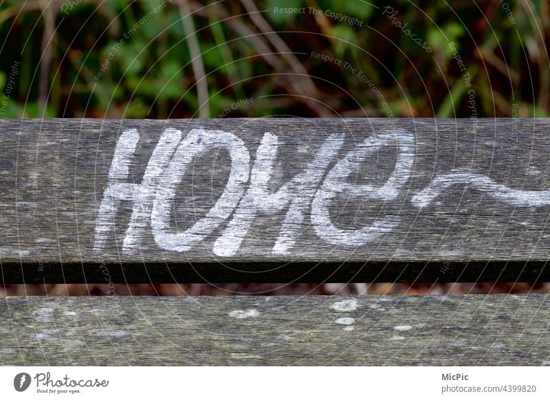 Home Bank Parkbank Brett Holz Aufschrift Graffiti Schriftzug zuhause Außenaufnahme Menschenleer Sitzgelegenheit Erholung Einsamkeit ruhig Holzbank home