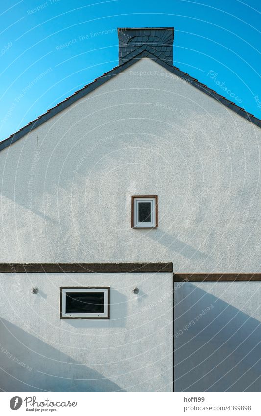 zwei Fenster in schlichter Aussenfassade eines Reihenhauses mit Garage  und Schornstein einfach Zwei minimalistisch Minimalismus blau Blauer Himmel Fassade