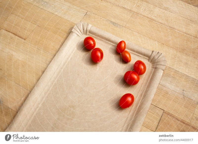 Sieben kleine Tomaten auf grauem Pappteller tomate ernte frisch obst gemüse pappteller tisch holztisch sieben rot cocktailtomate textfreiraum garten