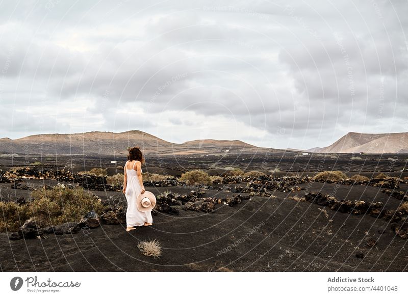 Anonyme Frau, die in einem trockenen Tal spazieren geht Spaziergang trocknen reisen wolkig Himmel Buchse Hügel erkunden Fuerteventura Spanien Kanarische Inseln