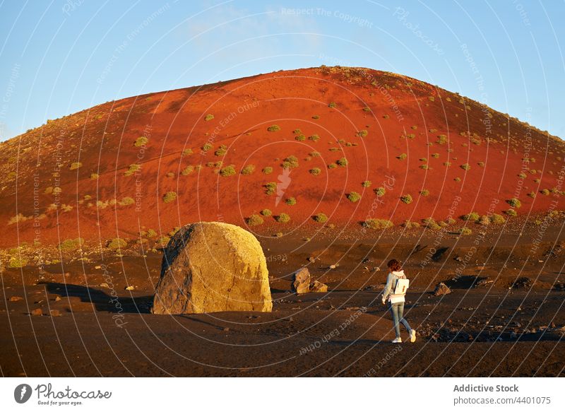 Frau geht in der Nähe von Hügel und Stein Spaziergang Landschaft trocknen Sommer Reisender erkunden tagsüber Fuerteventura Spanien Kanarische Inseln Natur