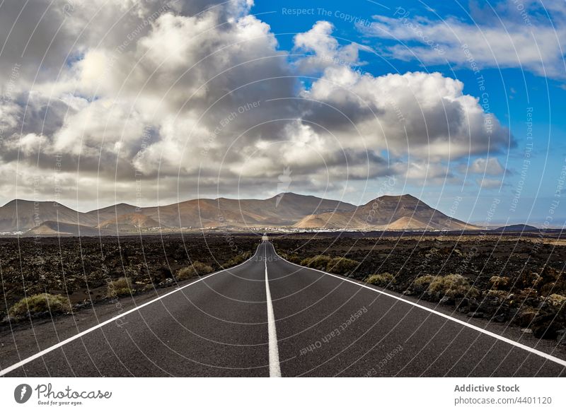 Asphaltstraße im Tal in der Nähe der Berge Straße Berge u. Gebirge Feld Morgen Natur Landschaft Himmel wolkig Fuerteventura Spanien Kanarische Inseln Autobahn