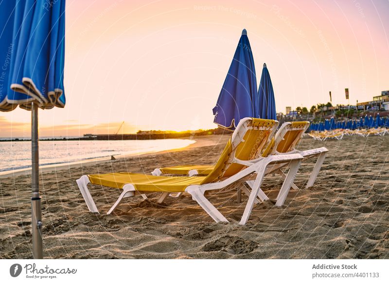 Liegestühle und Sonnenschirme am Strand bei Sonnenuntergang Regenschirm Resort Urlaub Sommer MEER Sand Feiertag Fuerteventura Spanien Kanarische Inseln Seeküste