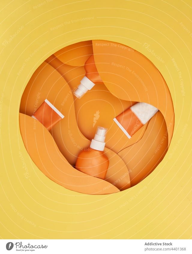 Tuben mit Sonnencreme auf orangem und gelbem Hintergrund Sahne Flasche Kosmetik Pflege Lotion Hautpflege Schutz Stillleben Textfreiraum Körper Schönheit Sommer